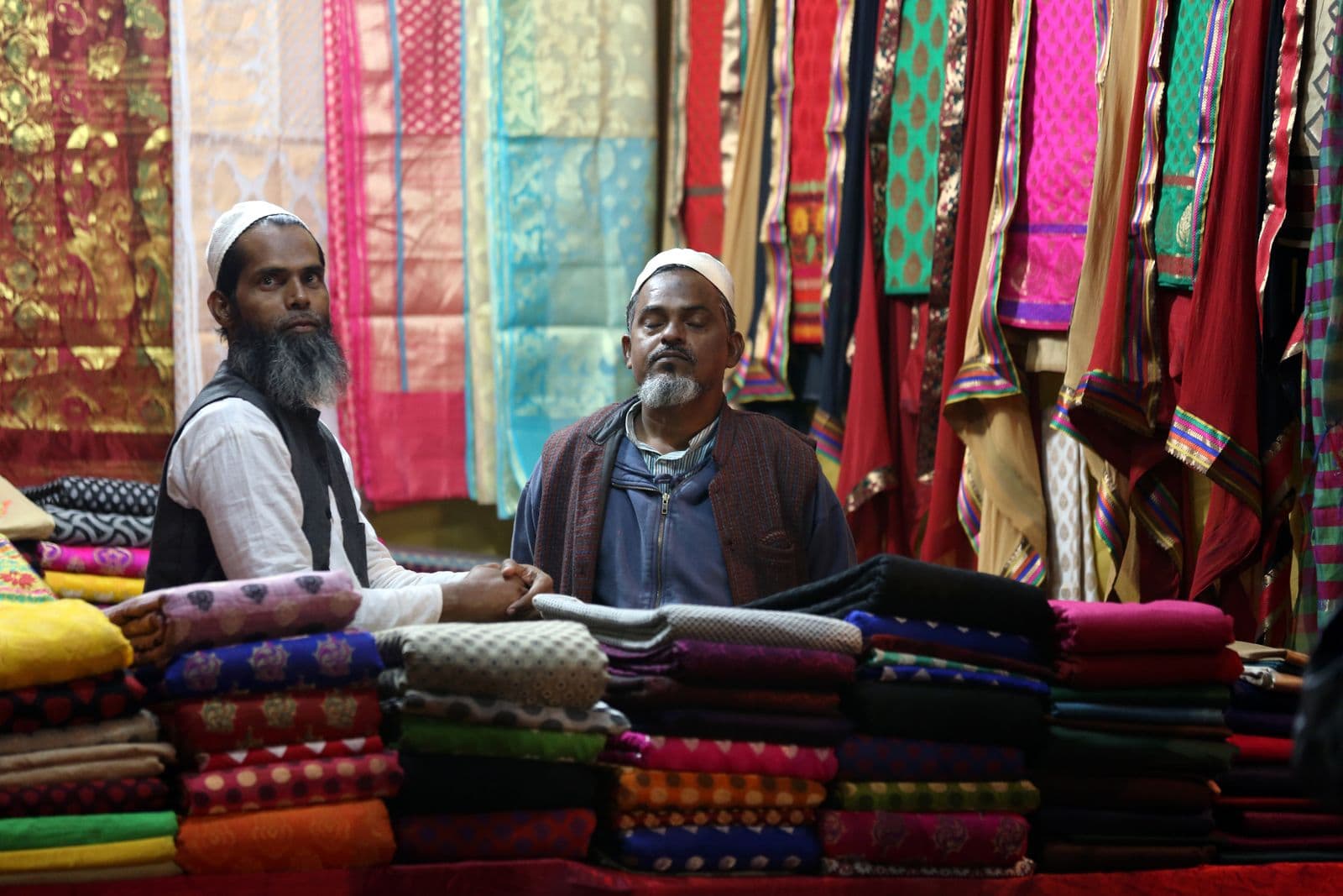 Textile shop owner showing fabric to a customer