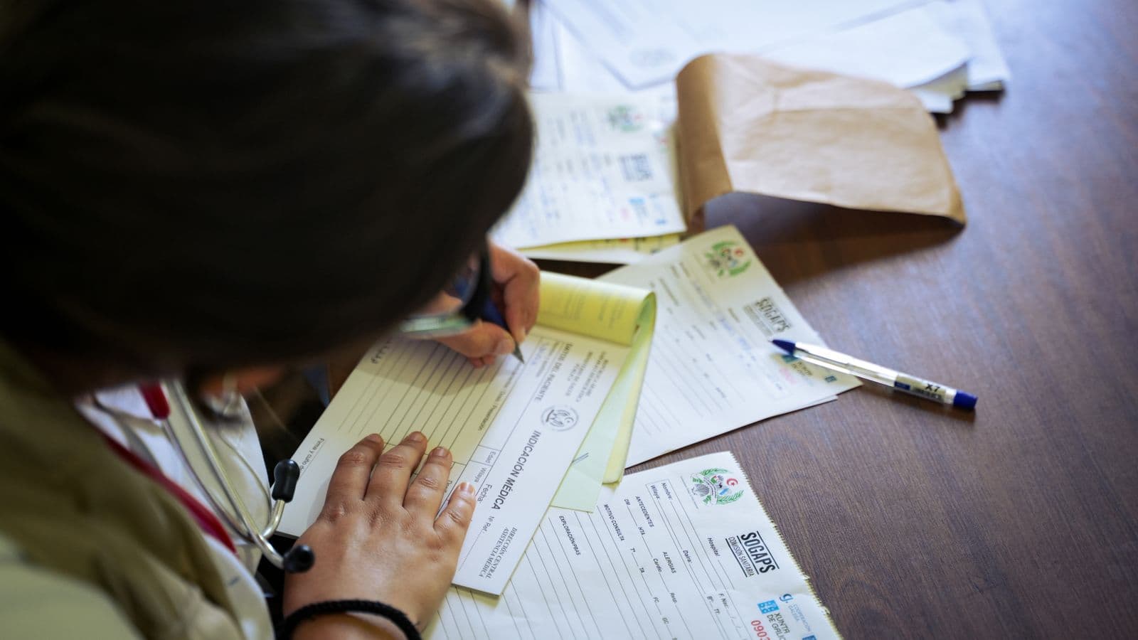Filling in a paper form and records at a desk