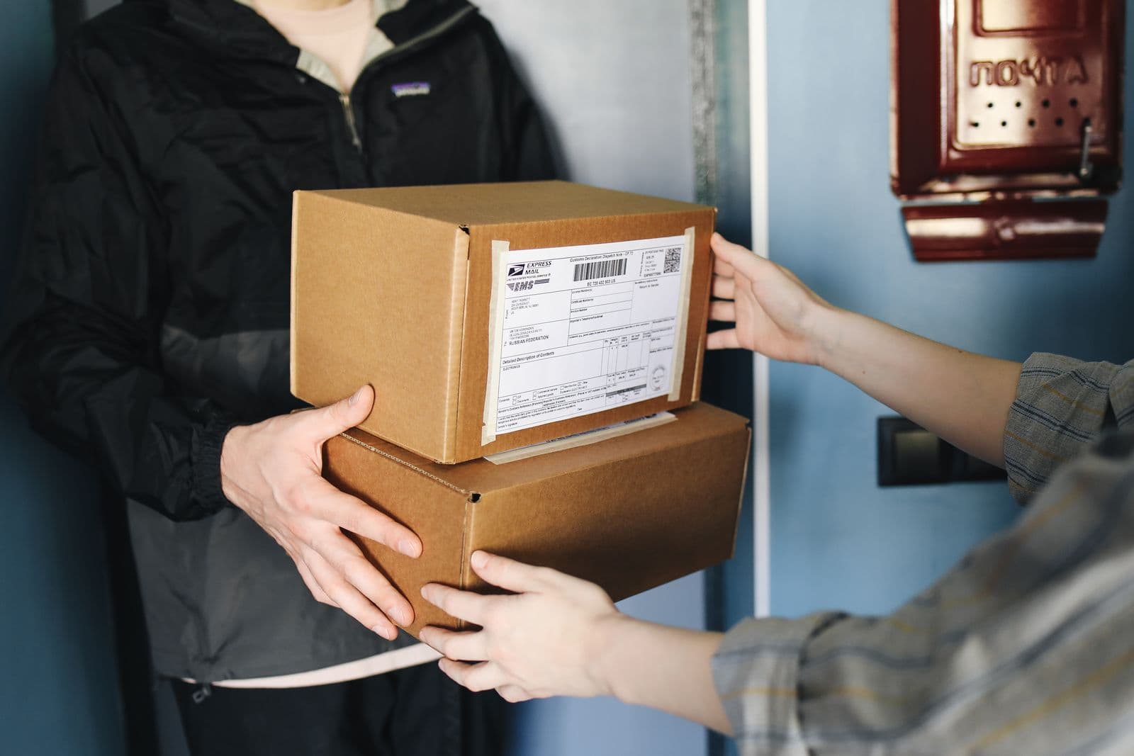 Courier handing a parcel box to a customer at the door