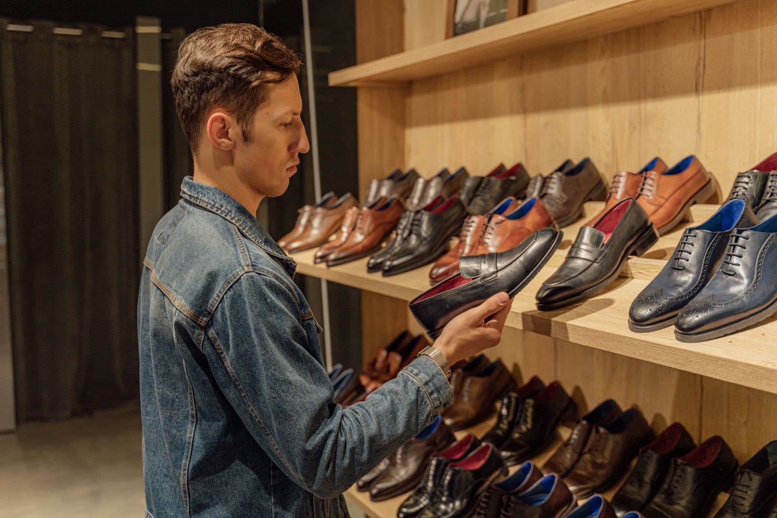 Shoe store owner with a customer among footwear shelves