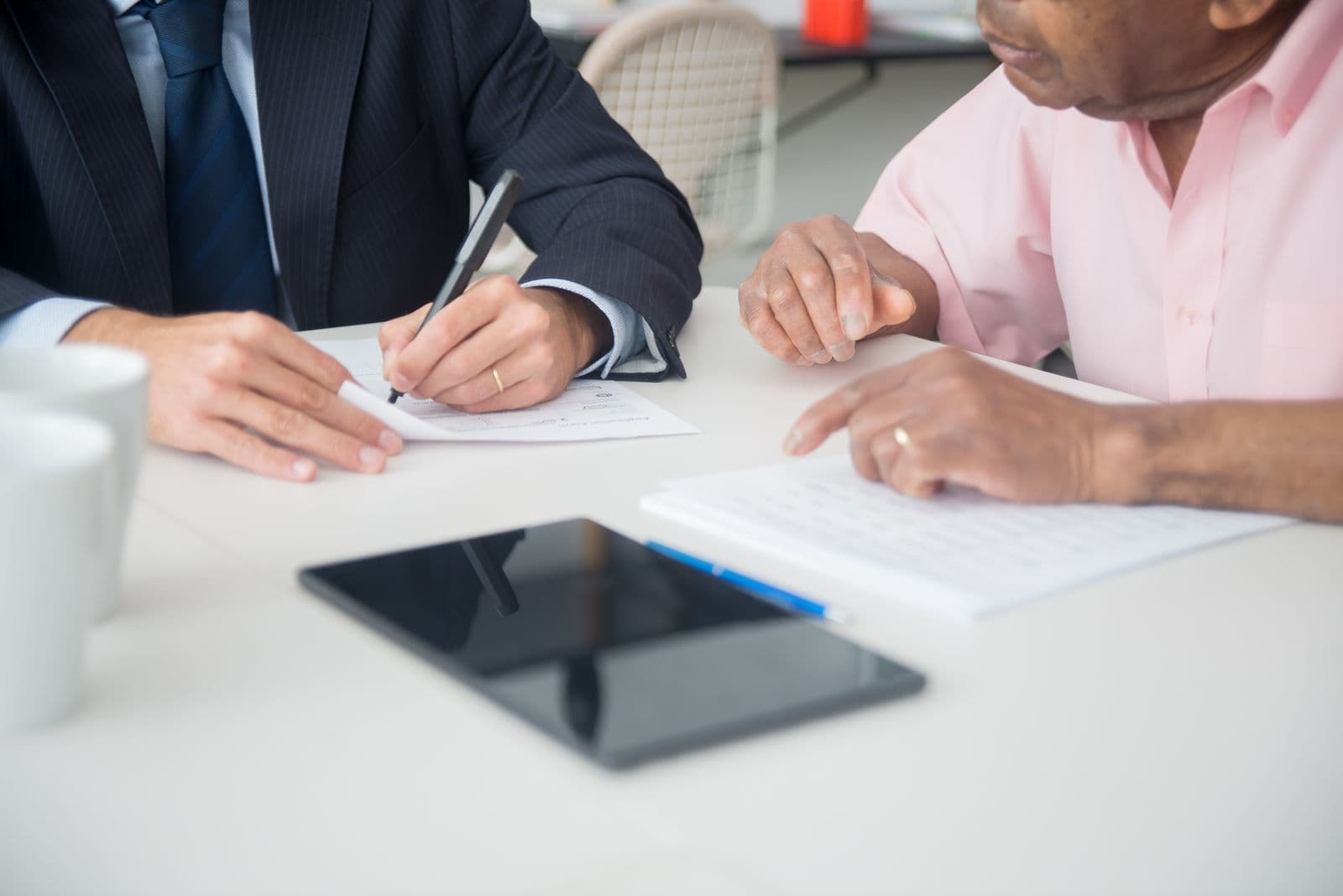 Person signing a contract on a tablet