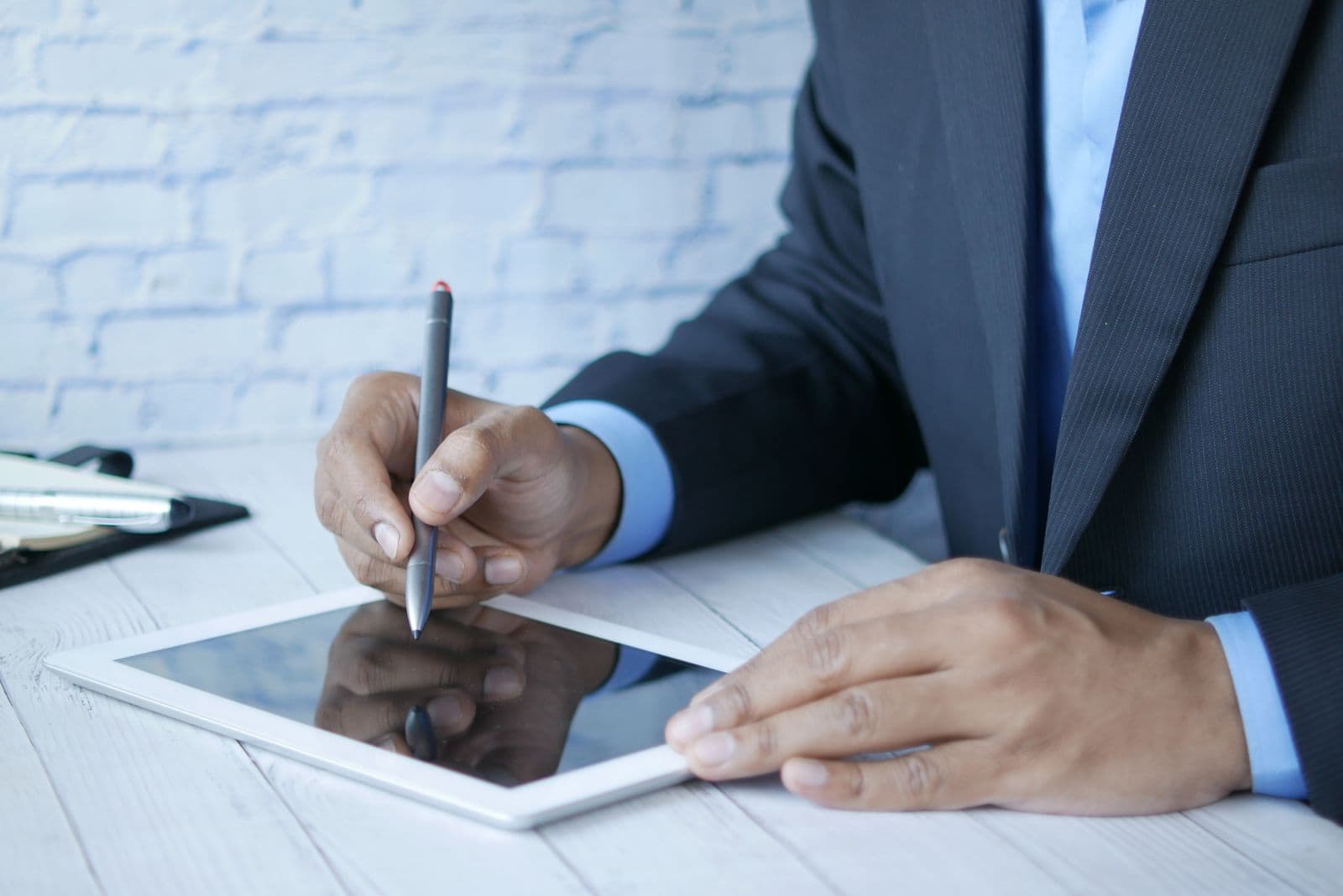 Finger signing a signature on a tablet touchscreen